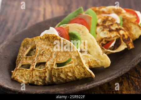 Pancakes sutffed with ham, cheese, tomatoes and spinach Stock Photo