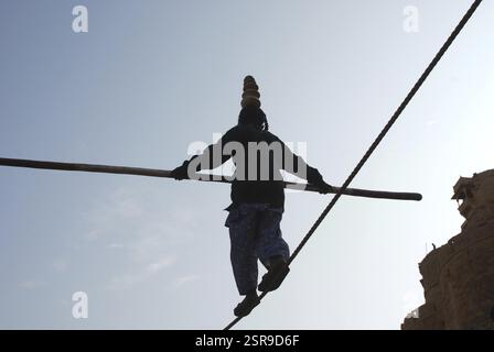 Girl balancing with bamboo in hand on rope, Jaisalmer, Rajasthan, India ...