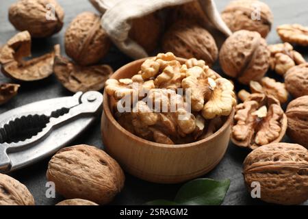 Fresh ripe walnuts, shells and nutcracker on table, closeup Stock Photo