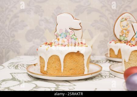 Traditional Easter dinner or brunch with ham, colored eggs, hot cross buns, cake and vegetables. Easter meal dishes with holday decorations. Stock Photo