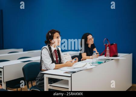 Students attentively listening during a classroom lecture session Stock Photo