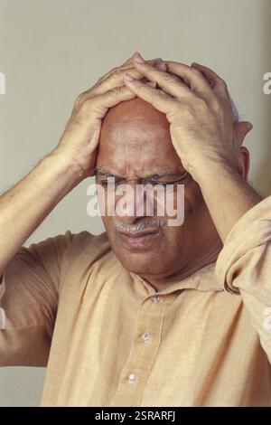 Man suffering through headache, India MR#176 Stock Photo
