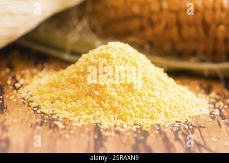 Corn groats and seeds, corncobs on wooden rustic table Stock Photo