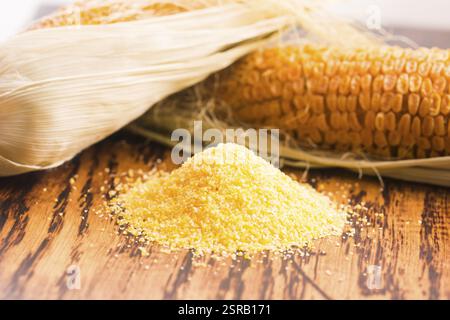 Corn groats and seeds, corncobs on wooden rustic table Stock Photo