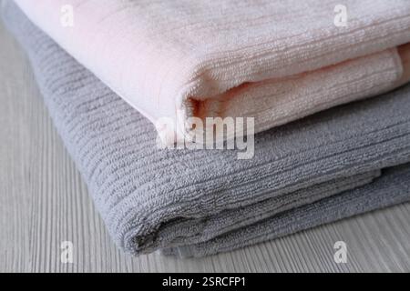 Pink and grey bath towels on the table. Hygiene, fabric,spa and textile concept. Pastel colors cotton towels. Stock Photo