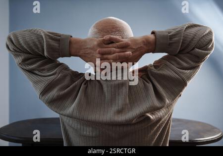 Senior man relaxing and sitting with hands behind head Stock Photo