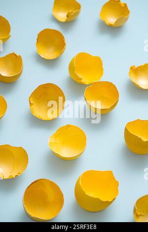 Cracked Yellow Easter Eggshells on Blue Background. Spring Symbolism, Fragile Beauty. Stock Photo