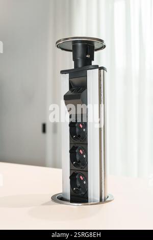 Table built-in socket. Fixed retractable power strip for home and office.  New technology. Modern style. Stock Photo