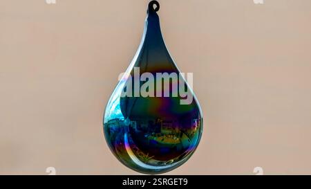 Iridescent Glass Droplet Ornament Reflecting Urban Cityscape on Soft Background Stock Photo