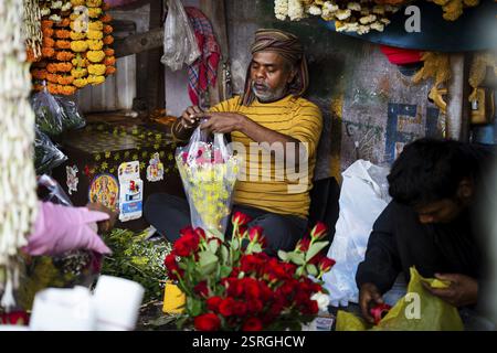 Vendor makes rose bouquet to sell in a street flower shop, on the occasion of Valentines day on February 14, 2025 in Guwahati, India. Valentine's Day Stock Photo