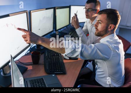 Showing graph place. Two stock traders working in the office with exchange technology. Stock Photo