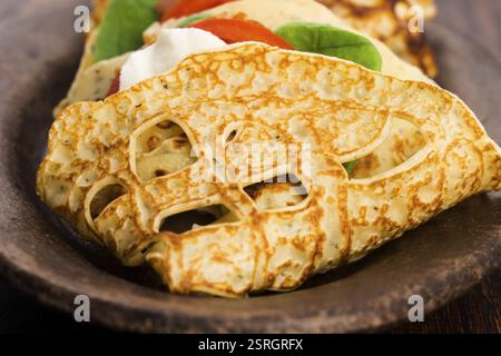 Pancakes sutffed with ham, cheese, tomatoes and spinach Stock Photo