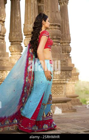 Lady in traditional wearing standing at heritage structure, India MR#746B Stock Photo