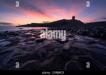 Beautiful sunrise at Dunstanburgh Castle on the Northumberland coastline, North East England. Stock Photo