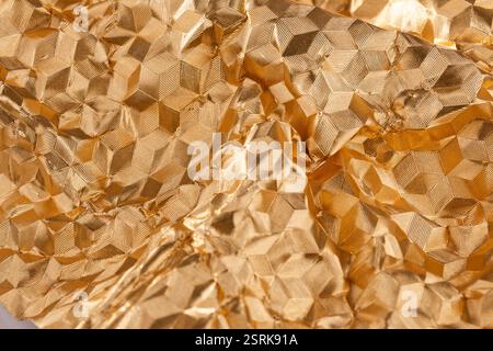 Close-up view of a golden, metallic, three-dimensional structure with light and shadow. Stock Photo