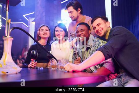 Positive emotions. Group of friends having fun in the night club together. Stock Photo
