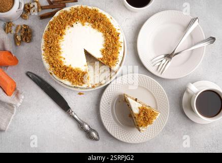 Top view of homemade carrot cake made with walnuts, iced with cream cheese. Cut piece on the plate. White background. carrot cake day Stock Photo