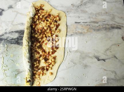 Rolling the dough with the filling into a roll. Cooking buns. Stock Photo