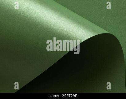Emerald green paper background with a glossy, satin texture and shimmering wavy edges. Deep forest and sage tones create an elegant, luxurious, and so Stock Photo