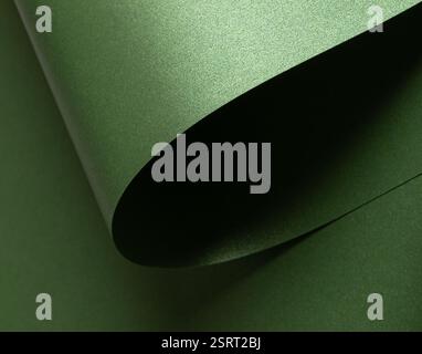 Emerald green paper background with a pearlescent, glossy texture and shimmering wavy edges. Deep forest and sage tones Stock Photo