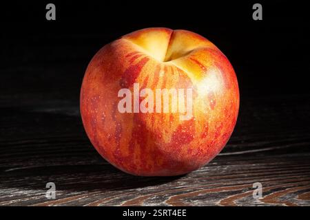 peach on black wood background Stock Photo