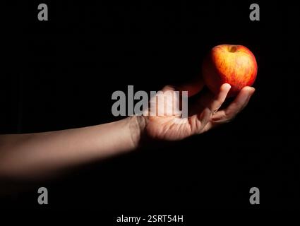 peach in hand on black background Stock Photo