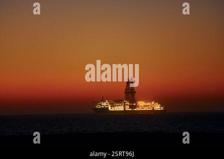 Distant majestic view of ship that is in the ocean at evening time. Stock Photo