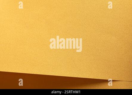 Golden saffron paper background with a smooth, grainy texture and subtle geometric lines. Deep ochre and mustard tones create a refined, classic, and Stock Photo