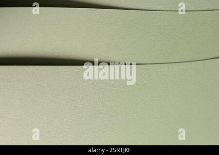 Pastel sage green paper background with a soft texture and layered folds. Muted olive and moss tones create a refined, elegant, and minimal abstract d Stock Photo