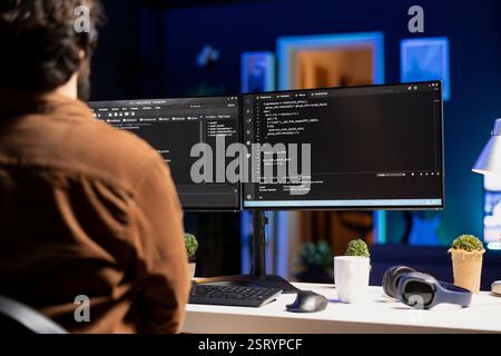Man working from home implementing security measures to protect company systems and data. Tech support IT worker writing, testing and debugging code for software applications Stock Photo