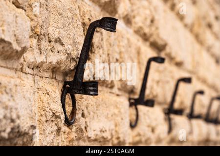 Close-Up of Metal Hooks on Stone Wall Stock Photo