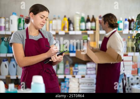 Female household goods store worker using tablet to manage inventory Stock Photo