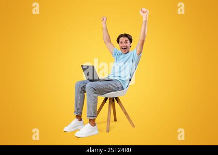 Excited guy using laptop celebrating success shaking fists Stock Photo