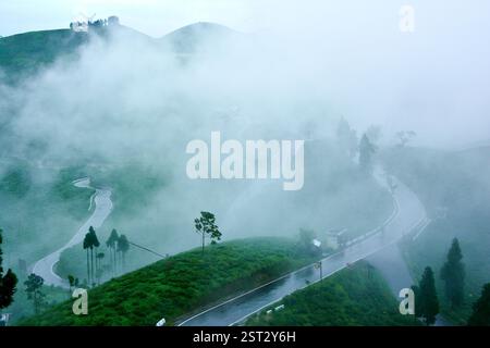 "Winding through Mirik’s misty roads, where the rain leaves silence and the fog whispers peace." Stock Photo