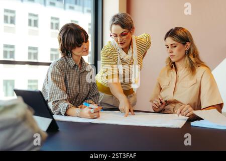 Professor guides college students in a modern classroom, fostering a collaborative environment for effective learning and understanding. Stock Photo