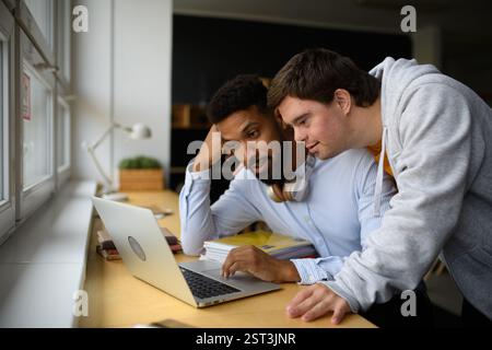 Tired young African-american teacher working on laptop. Stock Photo