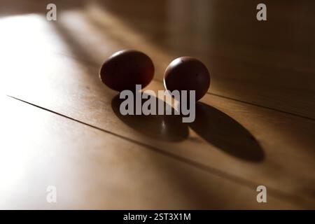 A silhouette of two brown eggs on wooden floor Stock Photo