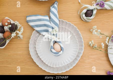 Easter egg wrapped in linen napkin in the shape of bunny with ears. Happy Easter  Stock Photo