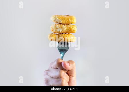 minimal fried chicken on fork In the hand Stock Photo