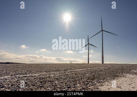 wind turbine in the snow with sun star and blue sky Stock Photo