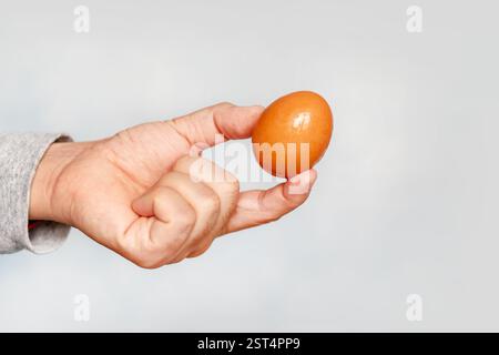man holds egg in hand, close up isolated on a white background Stock Photo