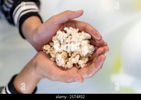 Close up image of a girl holding and picking pop corn top view Stock Photo
