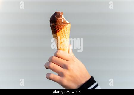 Female hand with a horn of ice cream on a light white background Stock Photo