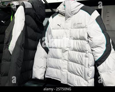 Lviv, Ukraine - February 16, 2025: Winter themed apparel display featuring Puma AMG Petronas Formula One Team stylish white and black puffer jackets h Stock Photo
