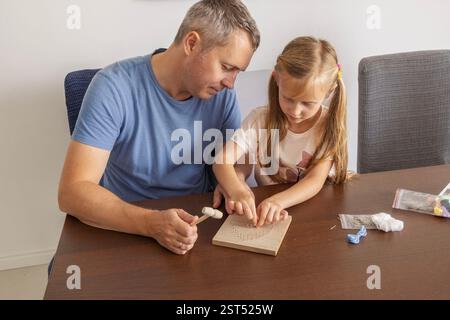 Father and daughter working on a DIY craft, sharing quality time and family connection happily Stock Photo