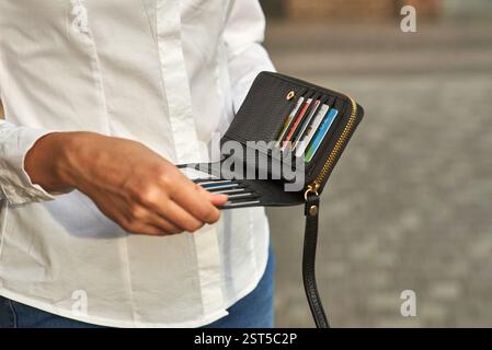 Close-up of hand holding black wallet with several credit cards inside, showcasing detail, business and finance theme Stock Photo