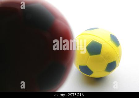 Small toy red and black, yellow and blue rubber football sport Stock Photo