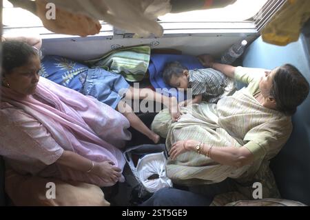 Trains Railways, A scene inside a train, Children sleeping while their grandmothers sitting watching outside the window of a running train, in Punjab Stock Photo