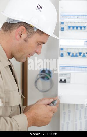 electrician installing energy saving meter Stock Photo