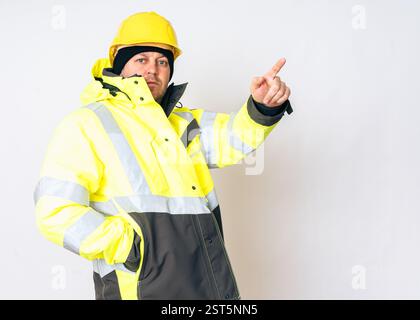 a man wearing a yellow working winter jacket and a yellow safety helmet . High quality photo Stock Photo